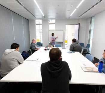 People sitting around a meeting room table at Moe Library