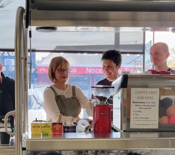 Image of coffee cart with four people learning and serving coffee.