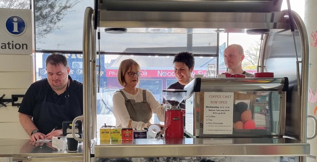Image of coffee cart with four people learning and serving coffee.