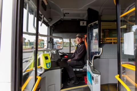 A bus driver sitting in a Latrobe Valley Buslines Bus ready to greet users.